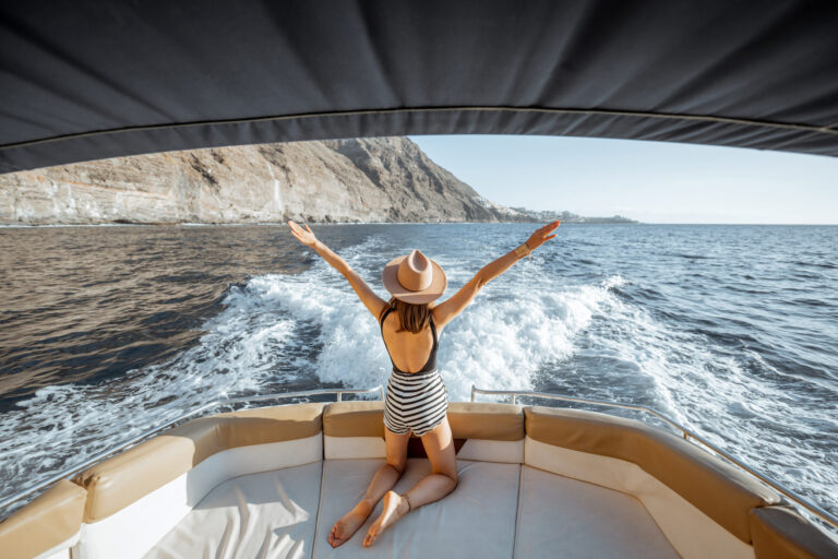Mujer relajada navegando en el yate cerca de la costa